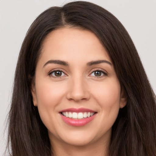 Joyful white young-adult female with long  brown hair and brown eyes