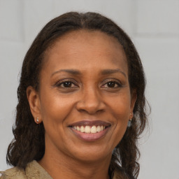 Joyful black adult female with long  brown hair and brown eyes