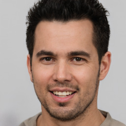 Joyful white young-adult male with short  black hair and brown eyes