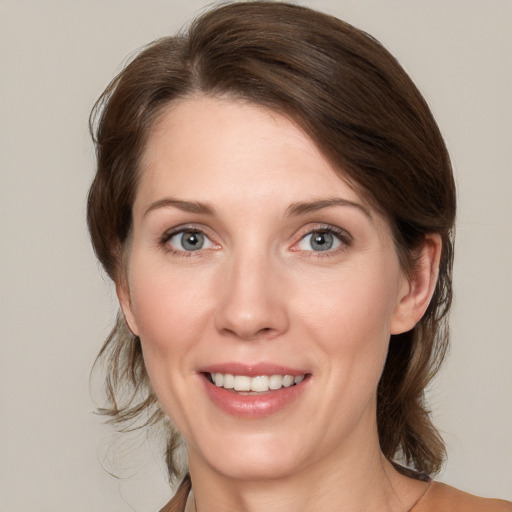 Joyful white young-adult female with medium  brown hair and grey eyes