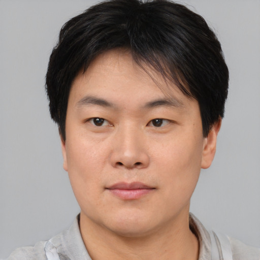 Joyful asian young-adult male with short  brown hair and brown eyes
