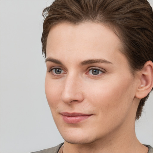 Joyful white young-adult female with short  brown hair and grey eyes