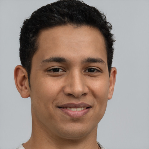 Joyful latino young-adult male with short  brown hair and brown eyes