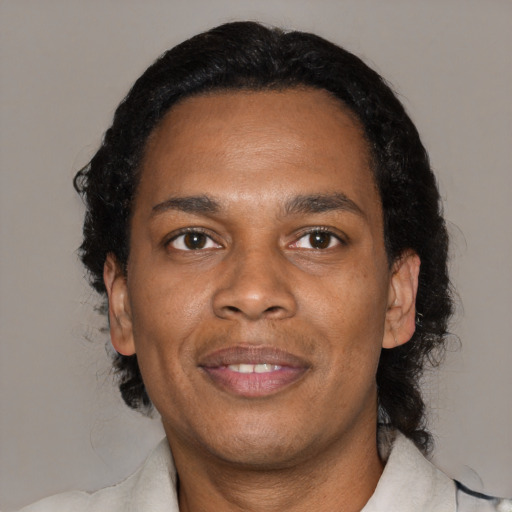 Joyful black young-adult male with medium  black hair and brown eyes