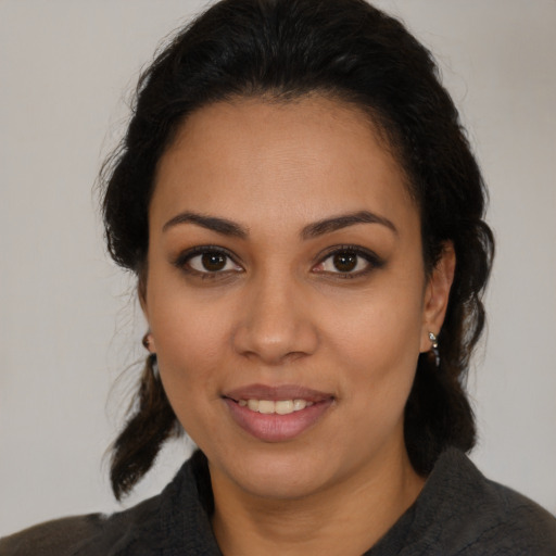 Joyful latino young-adult female with medium  brown hair and brown eyes