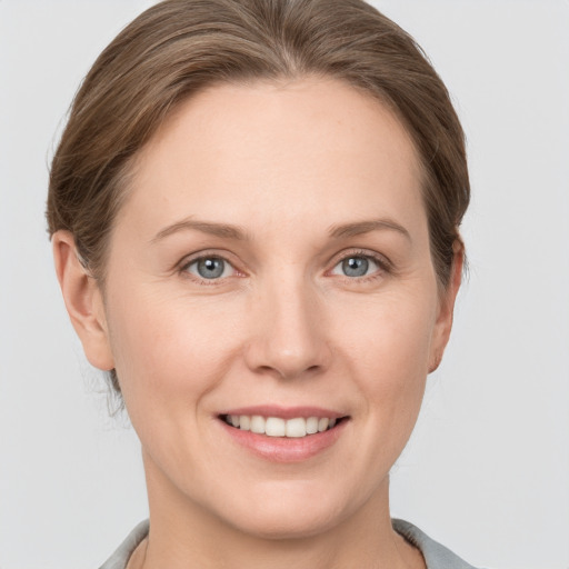 Joyful white young-adult female with short  brown hair and grey eyes