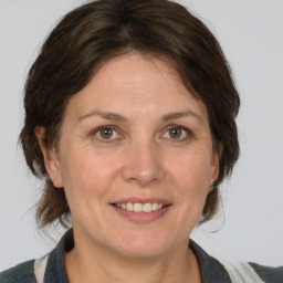 Joyful white adult female with medium  brown hair and grey eyes