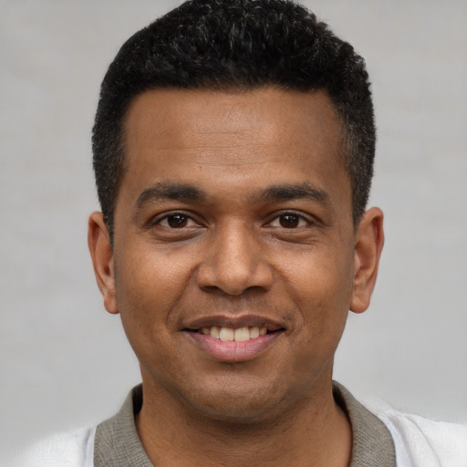 Joyful latino young-adult male with short  black hair and brown eyes