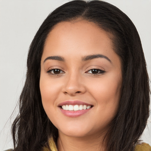 Joyful latino young-adult female with long  brown hair and brown eyes