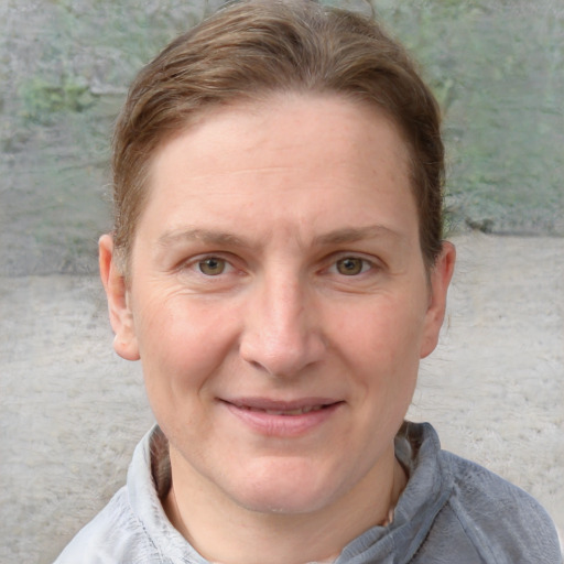 Joyful white adult female with short  brown hair and blue eyes