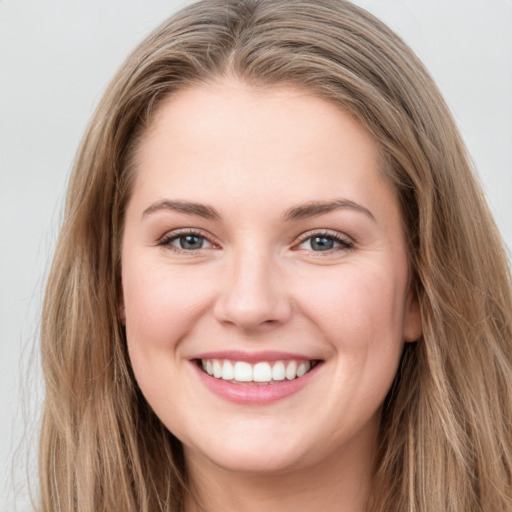 Joyful white young-adult female with long  brown hair and grey eyes