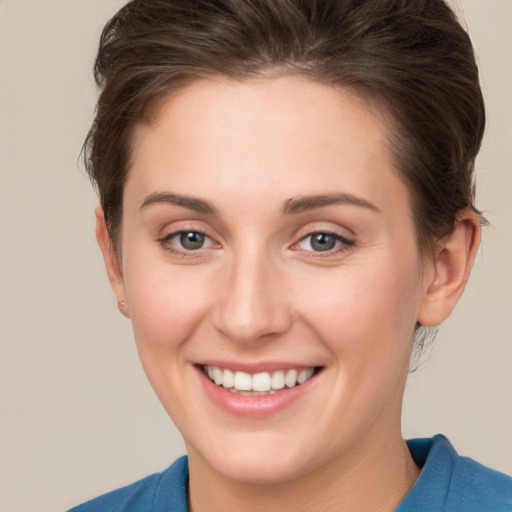 Joyful white young-adult female with medium  brown hair and grey eyes