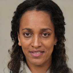 Joyful black adult female with long  brown hair and brown eyes