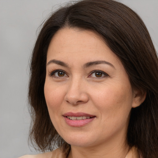 Joyful white adult female with medium  brown hair and brown eyes