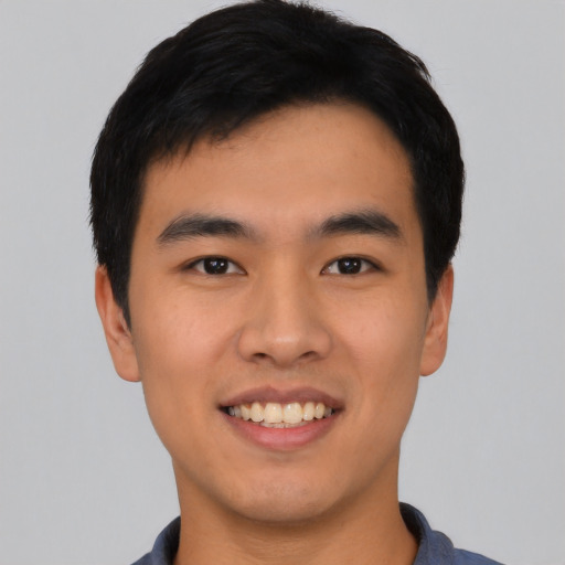 Joyful asian young-adult male with short  black hair and brown eyes