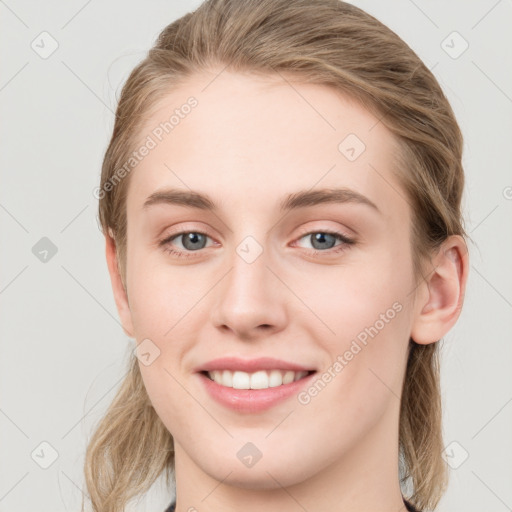 Joyful white young-adult female with long  brown hair and blue eyes