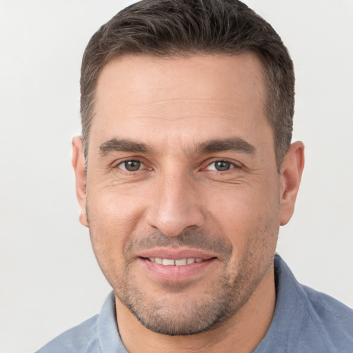 Joyful white adult male with short  brown hair and brown eyes