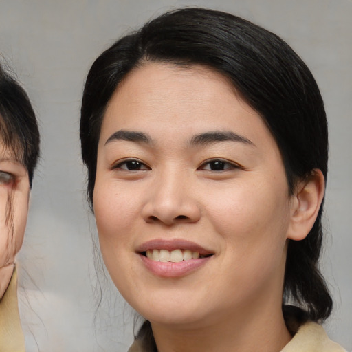 Joyful asian young-adult female with medium  black hair and brown eyes