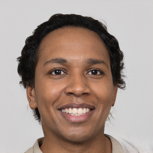 Joyful black young-adult male with short  black hair and brown eyes
