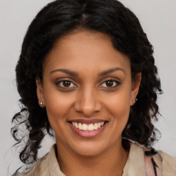 Joyful black young-adult female with long  brown hair and brown eyes