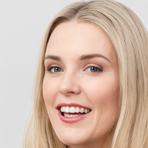 Joyful white young-adult female with long  brown hair and blue eyes