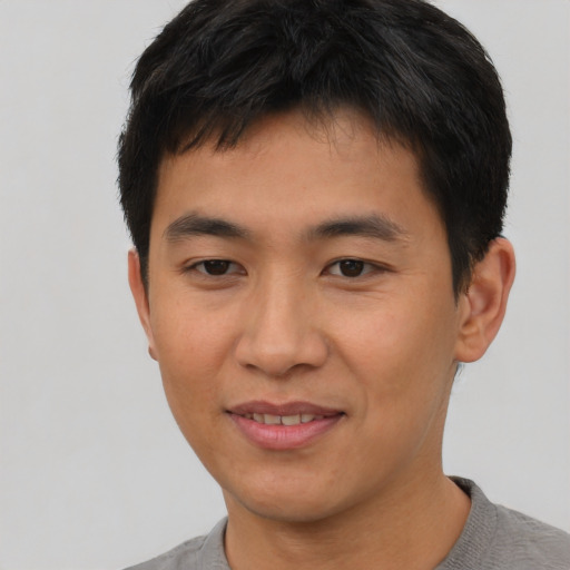 Joyful asian young-adult male with short  black hair and brown eyes