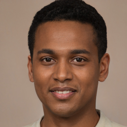 Joyful black young-adult male with short  black hair and brown eyes