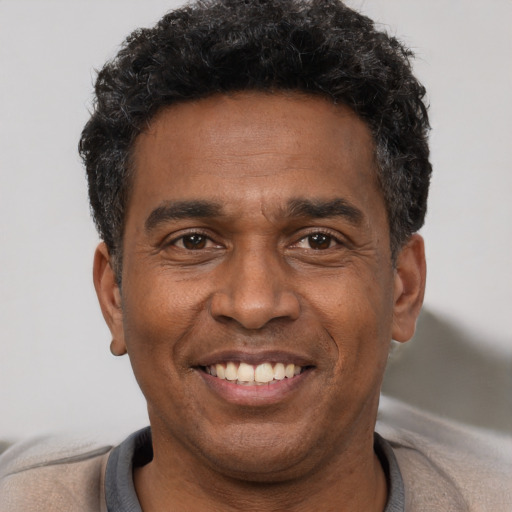 Joyful latino adult male with short  black hair and brown eyes