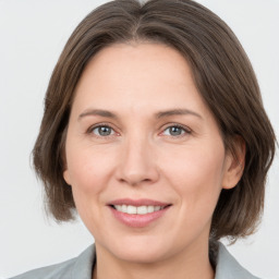 Joyful white adult female with medium  brown hair and grey eyes