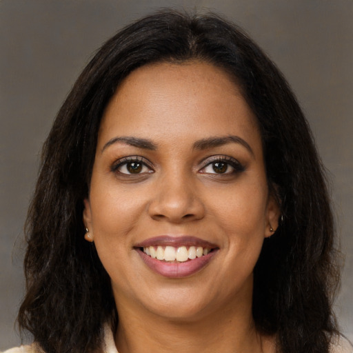 Joyful black young-adult female with long  brown hair and brown eyes