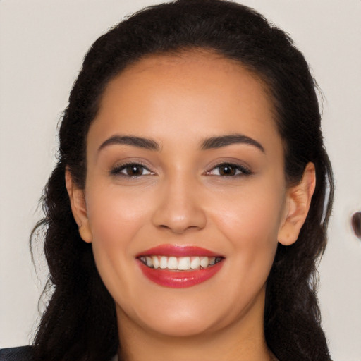 Joyful latino young-adult female with long  black hair and brown eyes