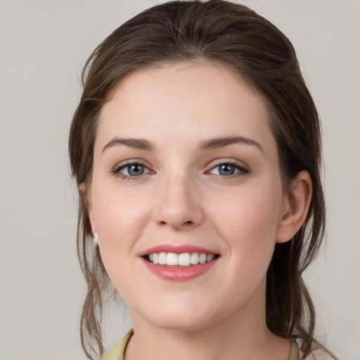 Joyful white young-adult female with medium  brown hair and grey eyes