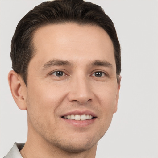 Joyful white young-adult male with short  brown hair and brown eyes