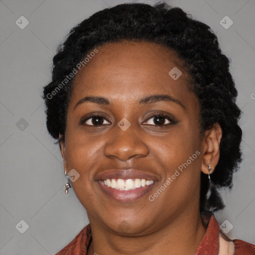 Joyful black young-adult female with long  black hair and brown eyes