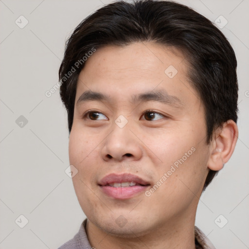 Joyful asian young-adult male with short  brown hair and brown eyes