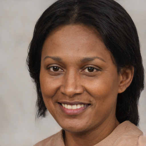 Joyful black adult female with medium  brown hair and brown eyes