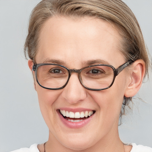 Joyful white adult female with medium  brown hair and blue eyes