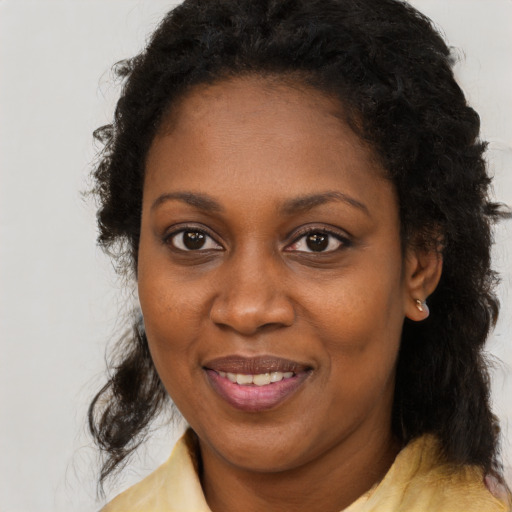 Joyful black young-adult female with medium  brown hair and brown eyes