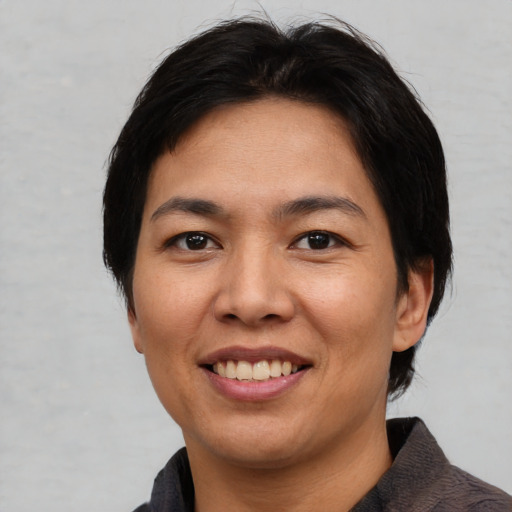 Joyful asian adult female with medium  brown hair and brown eyes