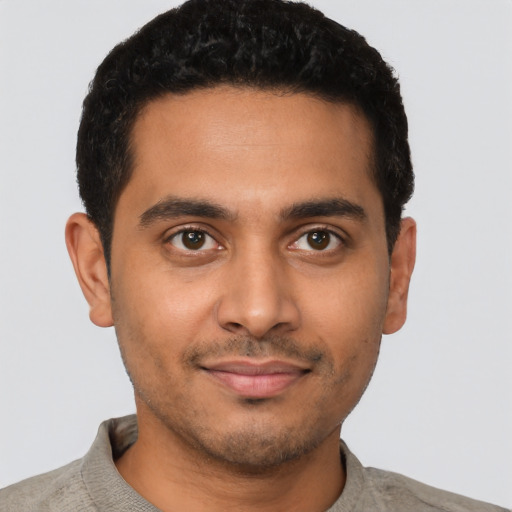 Joyful latino young-adult male with short  brown hair and brown eyes