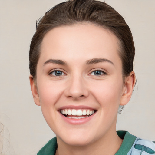 Joyful white young-adult female with medium  brown hair and green eyes