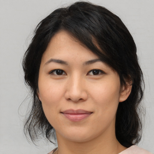 Joyful asian young-adult female with medium  brown hair and brown eyes