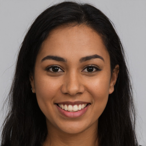 Joyful latino young-adult female with long  brown hair and brown eyes