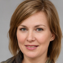 Joyful white adult female with medium  brown hair and blue eyes