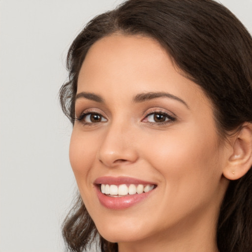 Joyful white young-adult female with long  brown hair and brown eyes