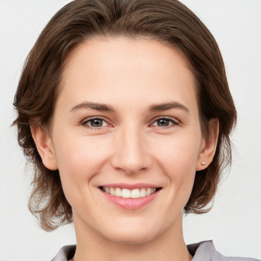 Joyful white young-adult female with medium  brown hair and grey eyes