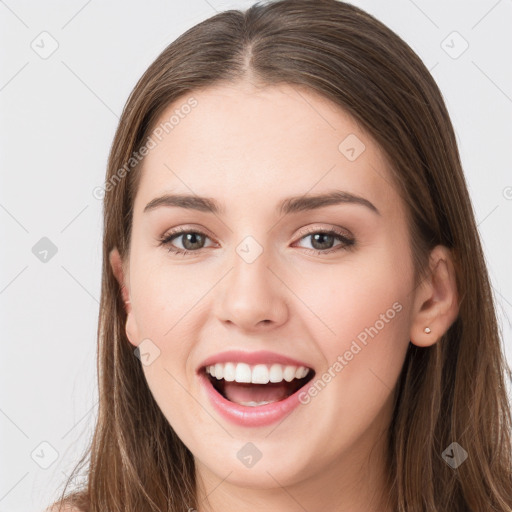 Joyful white young-adult female with long  brown hair and grey eyes