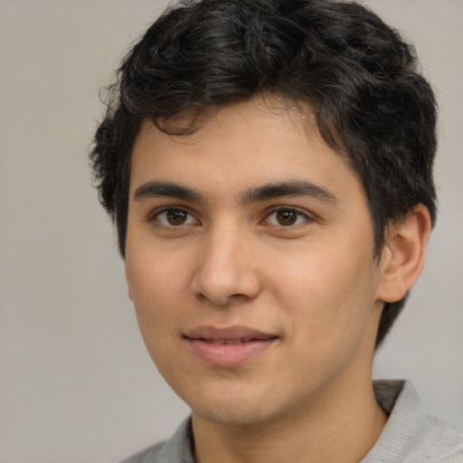 Joyful latino young-adult male with short  brown hair and brown eyes