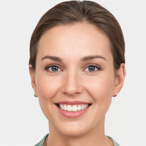 Joyful white young-adult female with short  brown hair and grey eyes