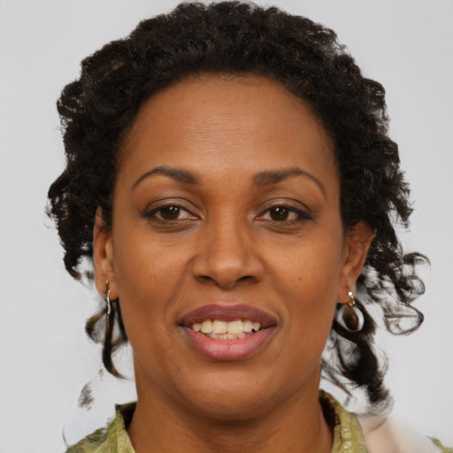 Joyful black adult female with medium  brown hair and brown eyes